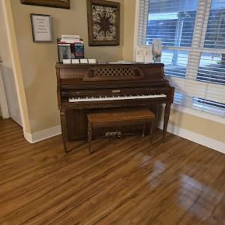 A beautiful wooden piano placed in a well-lit room, enhancing the home's ambiance.