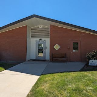 A modern brick building with a welcoming entrance and clear blue skies.