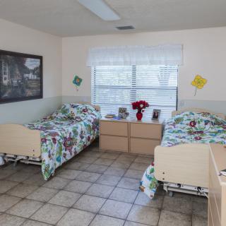 A shared hospital room with two beds, bright decor, and a window.