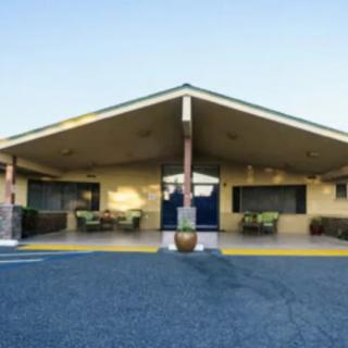 Exterior view of a motel with a distinctive triangular roof and parking area.