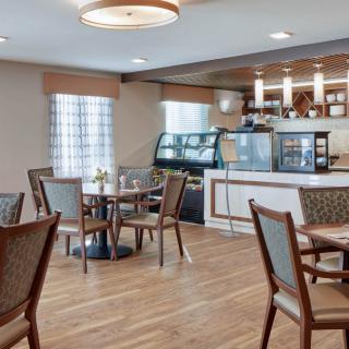 A cozy cafe interior with tables and chairs arranged near a service counter.