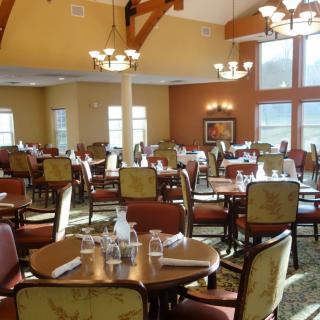 An elegant dining area set up with tables and chairs, ready for guests.