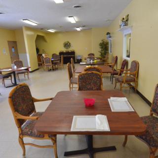 An empty dining room with several tables and chairs arranged neatly.