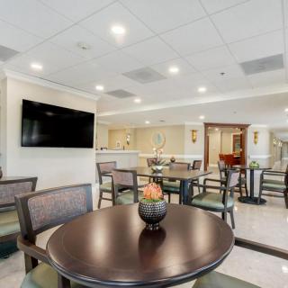 A modern hotel lobby with comfortable seating and a large television.