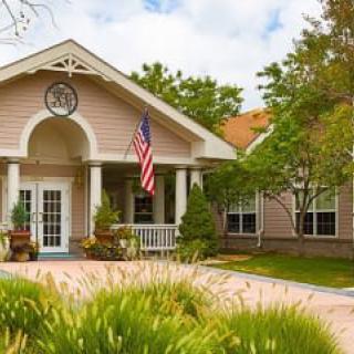 A charming residential house with a garden and American flag displayed at the entrance.