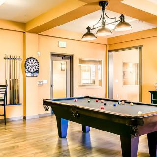 A modern game room featuring a pool table and a darts board.