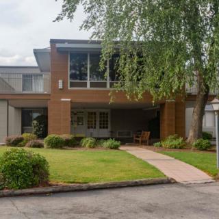 A modern two-story house with a brick exterior and well-maintained landscaping.