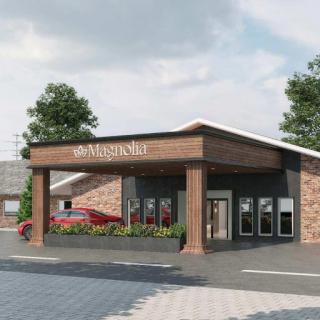 A modern restaurant exterior featuring stone and wood elements with landscaped surroundings.