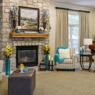 A cozy living room with a stone fireplace and comfortable seating.
