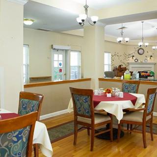 A cozy dining room with neatly arranged tables and chairs, featuring elegant decor.