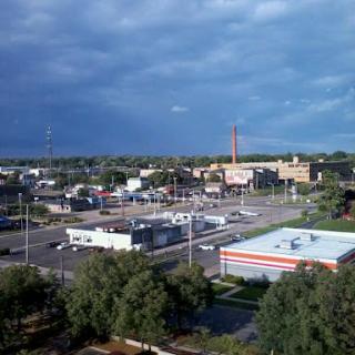 A panoramic view of a bustling urban area under a cloudy sky.