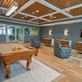 A modern game room featuring a pool table and comfortable seating.