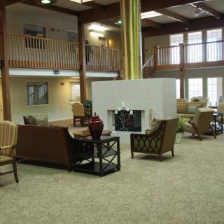 A spacious lobby with cozy seating around a central fireplace.