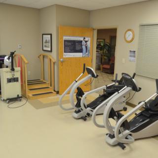 A physical therapy room featuring exercise equipment and rehabilitation tools.