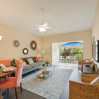 A cozy living room with a dining area, featuring stylish furniture and decor, leading to a balcony.