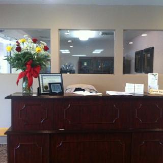 A reception desk with a floral arrangement and various office items.