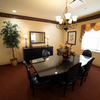 A well-furnished dining room featuring a black table surrounded by elegant chairs, complemented by decorative elements.