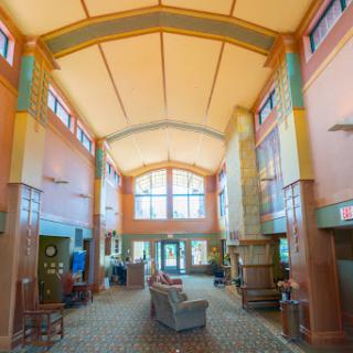 A spacious and colorful hotel lobby featuring large windows and comfortable seating arrangements.