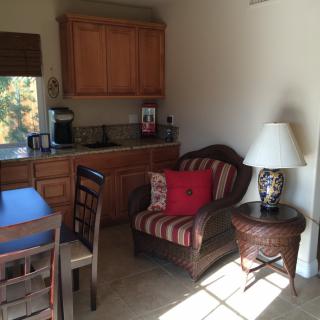 A cozy corner of a living space with a kitchenette and seating area.