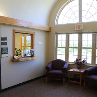 A bright and welcoming waiting area with comfortable seating and large windows.