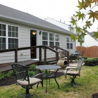 A cozy backyard setup featuring a patio with chairs and a table, perfect for outdoor gatherings.