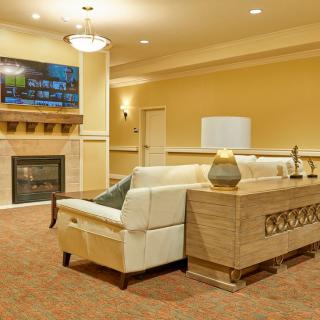 A cozy living room with modern decor, featuring a plush sofa, fireplace, and television.
