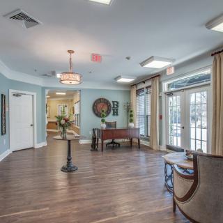 A spacious and elegant lobby with wooden flooring, stylish furniture, and decorative elements.