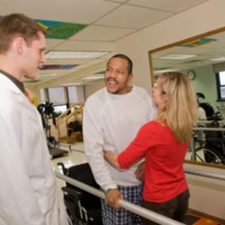 A patient receives support and guidance from a therapist during a physical therapy session.