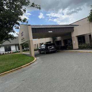 Entrance of a healthcare facility with cloudy skies overhead.