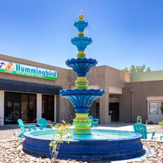 A vibrant fountain stands at the entrance of a shopping center, adding charm to the outdoor space.