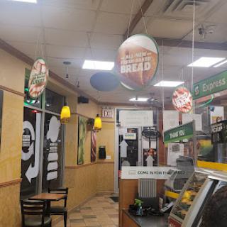 Interior view of a fast food restaurant showcasing the dining area and menu signage.