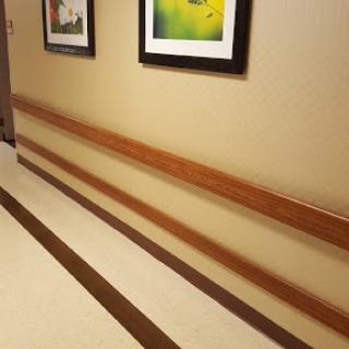 A serene interior hallway featuring framed artwork and a polished wooden railing.
