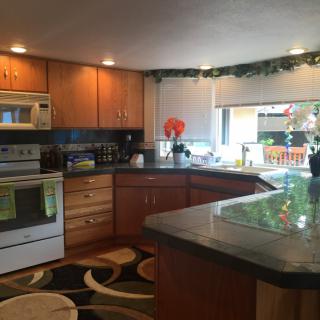 A modern kitchen with wood cabinets, an oven, microwave, and a central island.
