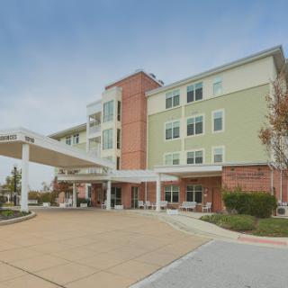 A modern hotel with a welcoming entrance and spacious parking area.