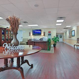 A welcoming reception area featuring a large table with decorative items and a hallway leading to other parts of the building.