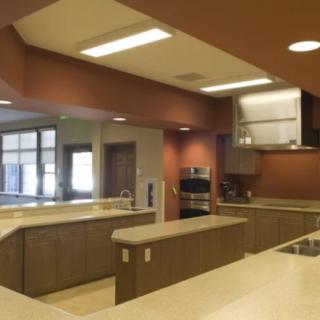 A modern kitchen with wood cabinets and a central island, featuring recessed lighting.