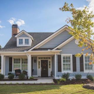 A charming suburban house with a well-kept front yard and trees.