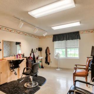 A well-lit hair salon interior with styling chairs and a large mirror.
