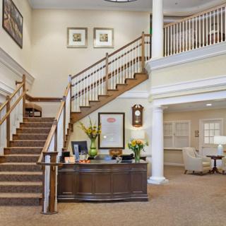 A spacious lobby with a staircase and reception area.
