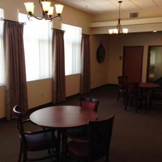 A quiet dining area with round tables, chairs, and soft lighting.