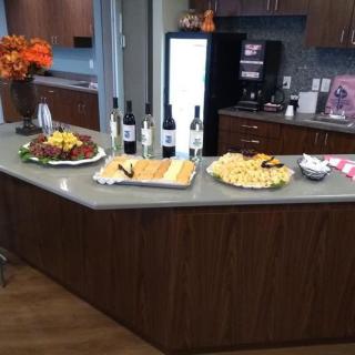 A kitchen counter set with a display of wine bottles and various appetizers.