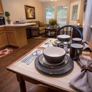 A cozy dining area with a neatly set table in an open-plan kitchen and living room.