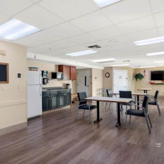 A modern community kitchen and dining area with tables and chairs.