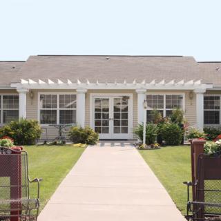 A single-story house with a well-maintained front yard and pathway leading to the entrance.