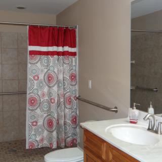 A bathroom with a colorful shower curtain and a clean countertop.