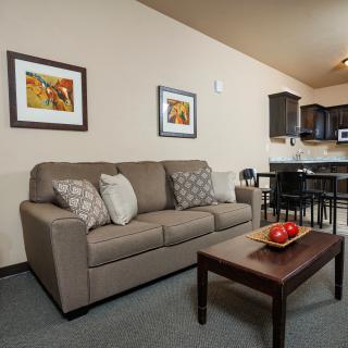 A cozy living room with a sofa, coffee table, and adjoining kitchen area.