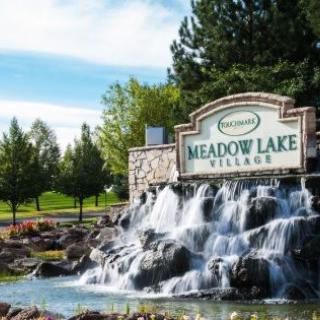 Entrance to Meadow Lake Village with a waterfall feature and landscaping.