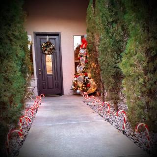 A beautifully decorated entrance for the holiday season, featuring a wreath, festive lights, and lush greenery.