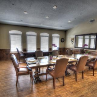 A well-lit conference room set up for a meeting, featuring a long table surrounded by comfortable chairs.