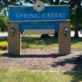 The entrance sign for Spring Creek, surrounded by well-maintained landscaping.